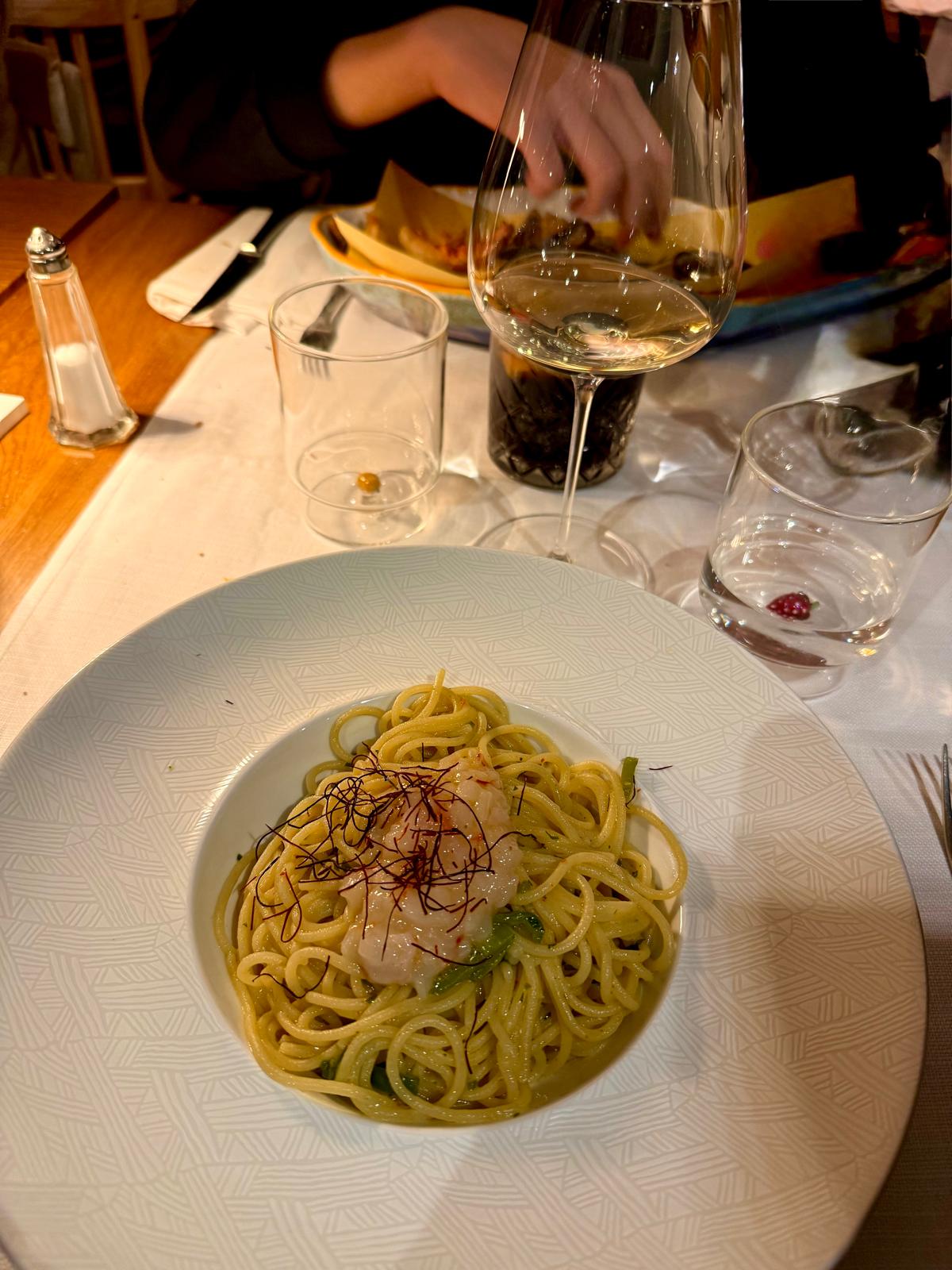 Elegant restaurant spaghetti with prawn and saffron threads on a white plate